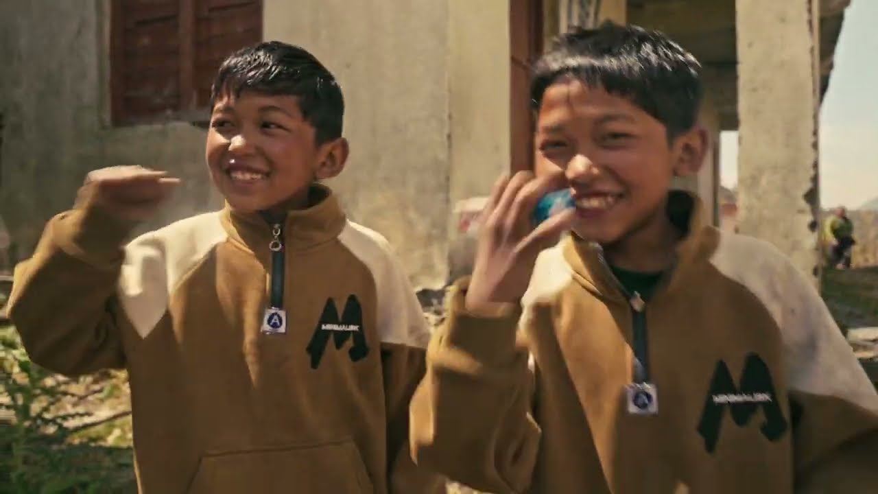 Two boys smile outside a Himalayan village clinic